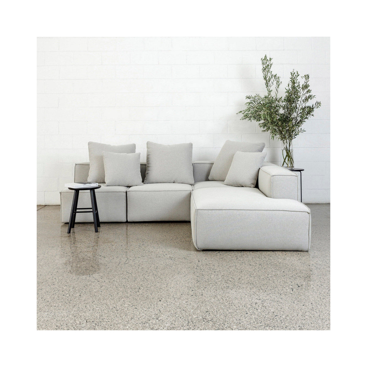 Baxter sectional in light grey with a chaise and scatter cushions